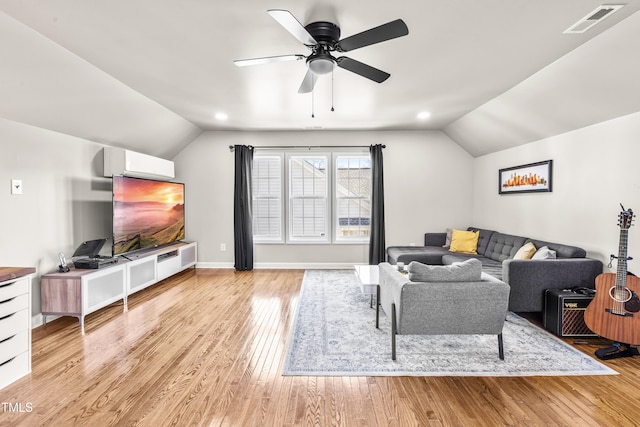 living room with visible vents, light wood-style flooring, vaulted ceiling, a wall mounted air conditioner, and baseboards