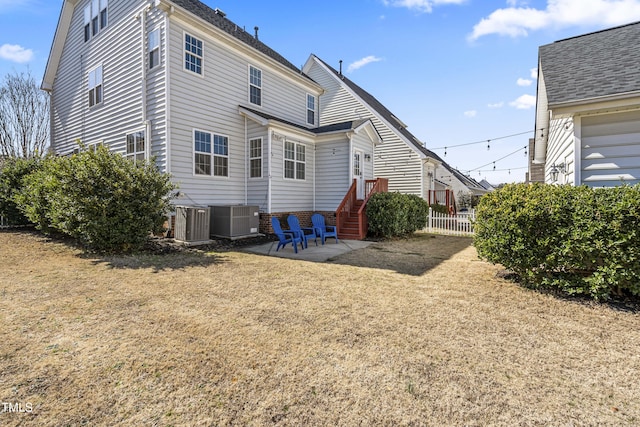 rear view of house featuring central AC unit, a patio area, and fence