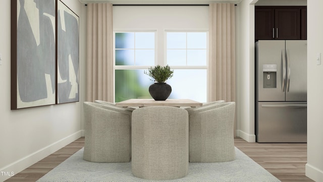 dining area with light wood finished floors and baseboards