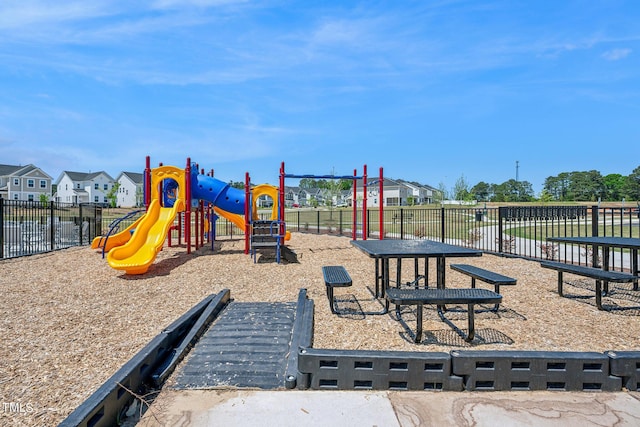 communal playground featuring fence and a residential view