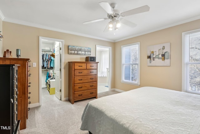 bedroom featuring light carpet, ornamental molding, multiple windows, and a walk in closet