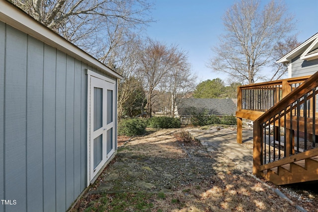 view of yard featuring a storage shed, stairway, a deck, and an outdoor structure