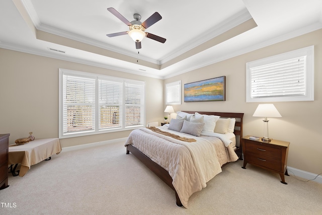 bedroom featuring ornamental molding, a tray ceiling, light carpet, and visible vents