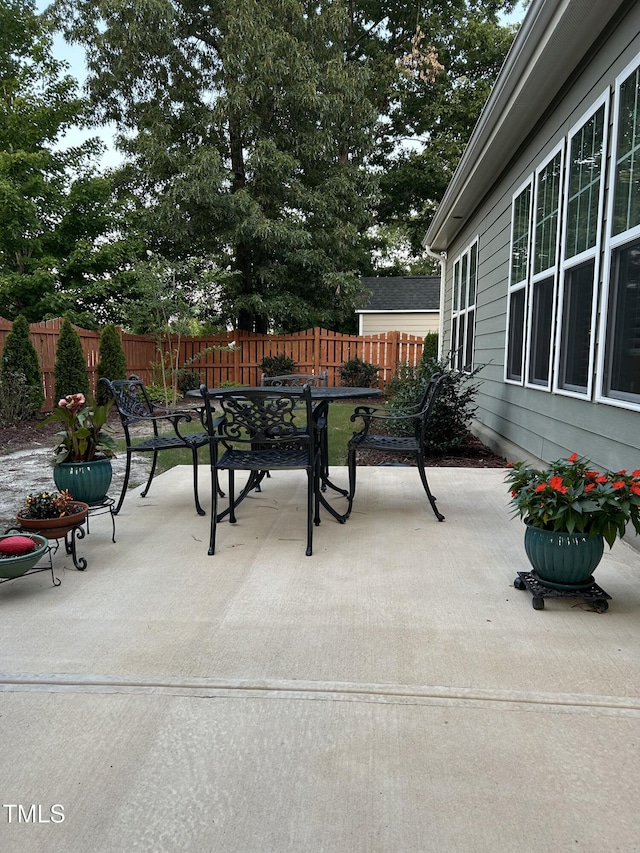 view of patio featuring outdoor dining area and fence