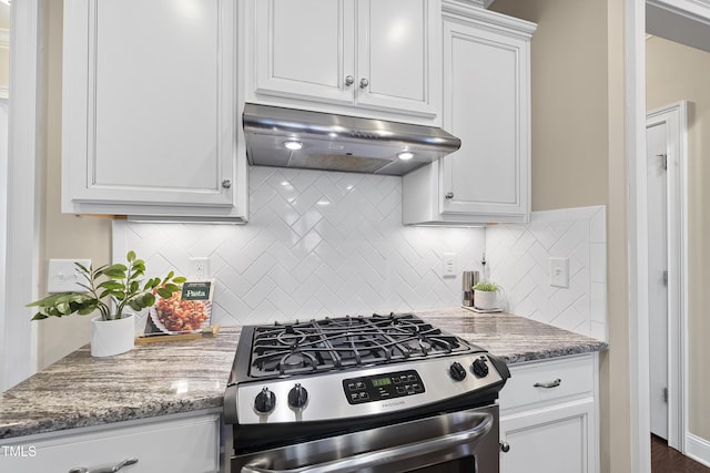 kitchen featuring white cabinets, decorative backsplash, gas range, and under cabinet range hood