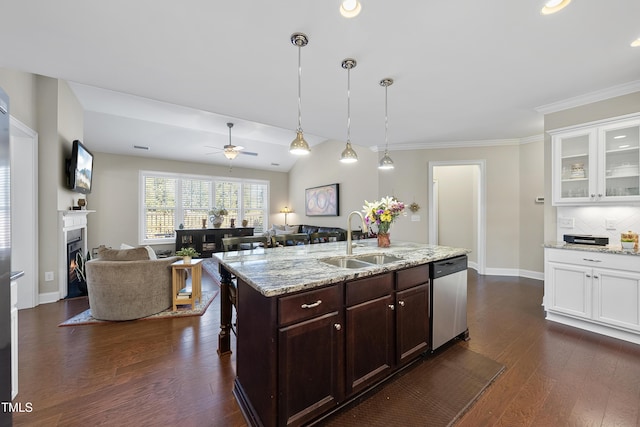 kitchen with a warm lit fireplace, dark wood finished floors, dishwasher, open floor plan, and a sink