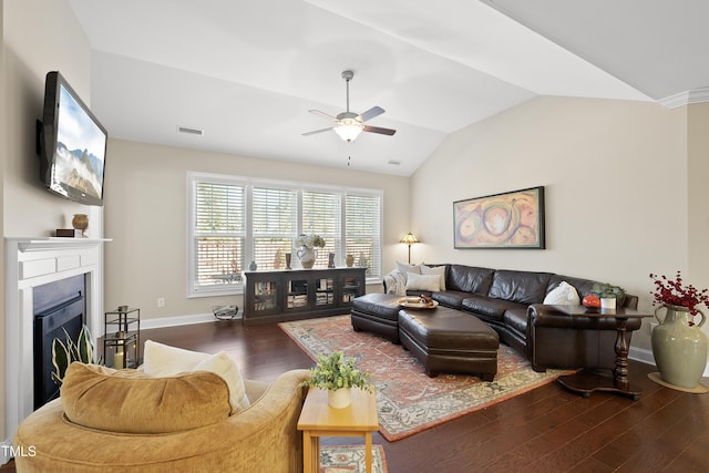 living area featuring baseboards, visible vents, wood finished floors, vaulted ceiling, and a fireplace