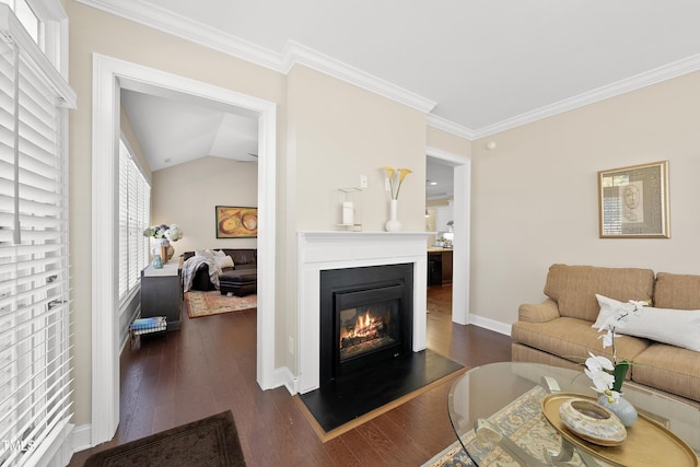 living room with dark wood-style flooring, baseboards, vaulted ceiling, a glass covered fireplace, and crown molding