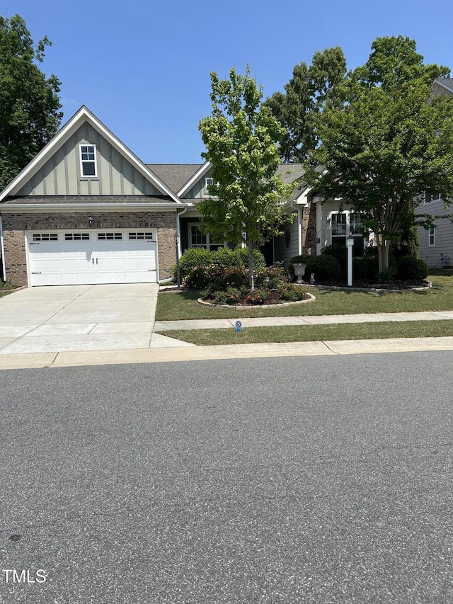 view of front of home with board and batten siding, brick siding, driveway, and an attached garage