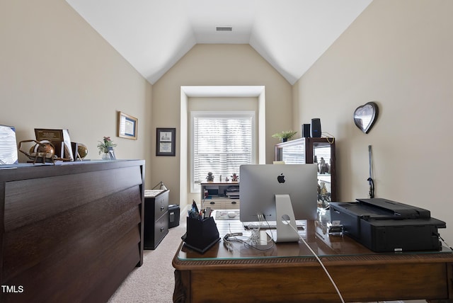office featuring vaulted ceiling, visible vents, and light carpet