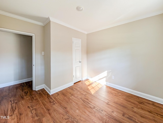 unfurnished bedroom featuring crown molding, baseboards, and wood finished floors