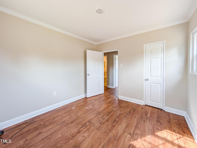 unfurnished bedroom with light wood-type flooring, baseboards, and ornamental molding