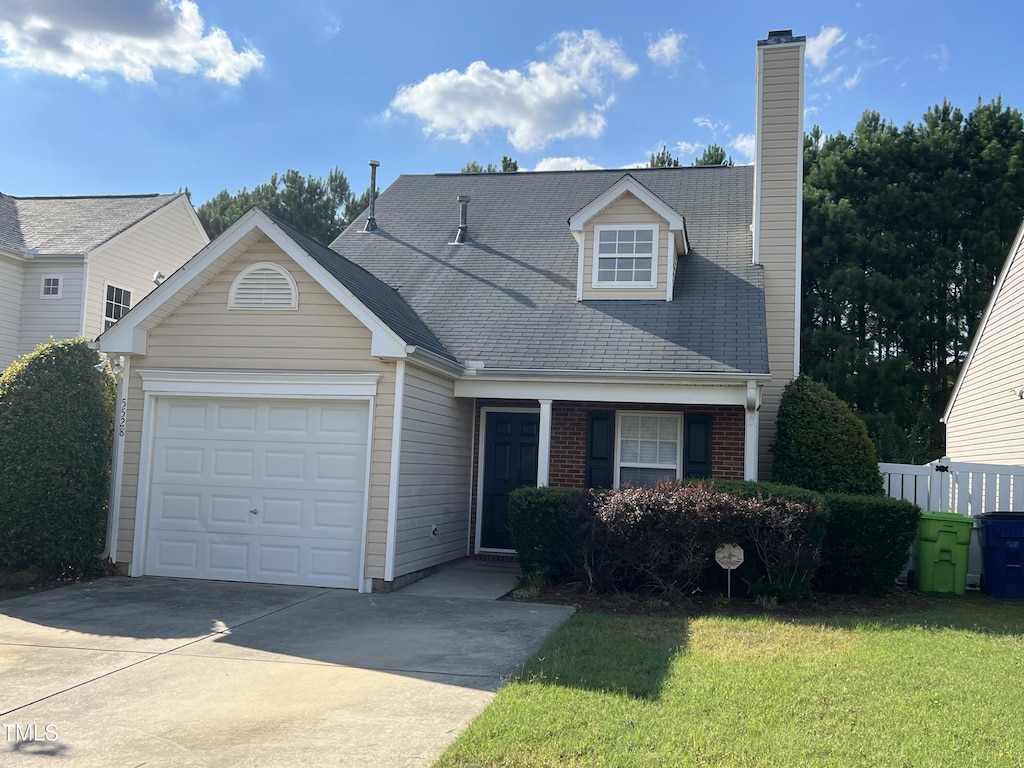 5528 Roan Mountain Pl, Raleigh, NC 27613 - view of front of property with brick siding, a chimney, a garage, driveway, and a front lawn