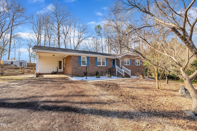 single story home featuring a carport, brick siding, and driveway