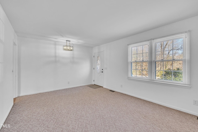 carpeted empty room featuring visible vents and baseboards