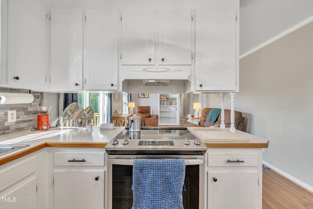 kitchen with light countertops, light wood-style floors, white cabinets, and stainless steel electric stove