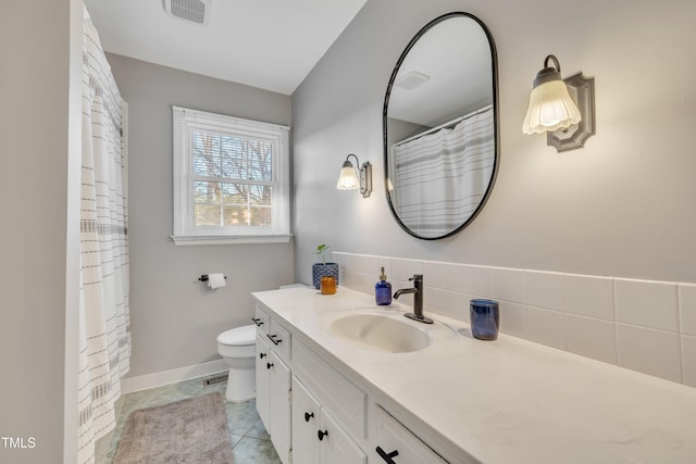 bathroom featuring tile patterned flooring, toilet, vanity, visible vents, and baseboards