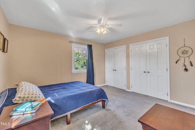 bedroom featuring a ceiling fan, carpet flooring, baseboards, and two closets