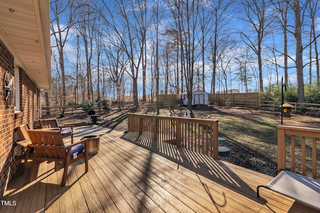 wooden deck featuring an outbuilding, a storage unit, and a fenced backyard