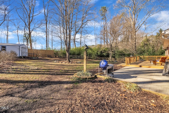 surrounding community featuring a shed, an outdoor structure, a wooden deck, and fence