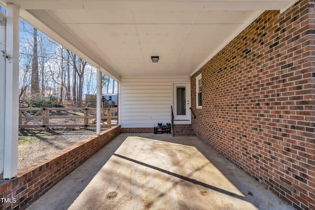 view of patio / terrace with a carport, entry steps, and fence