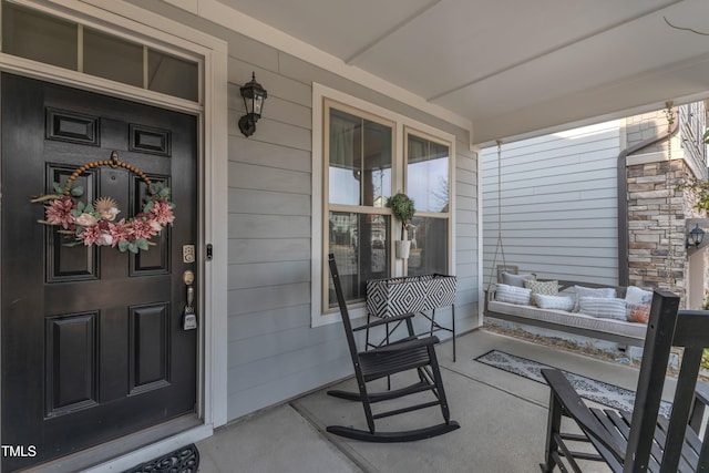 doorway to property featuring covered porch and stone siding