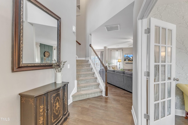 foyer entrance featuring stairs, wood finished floors, visible vents, and baseboards