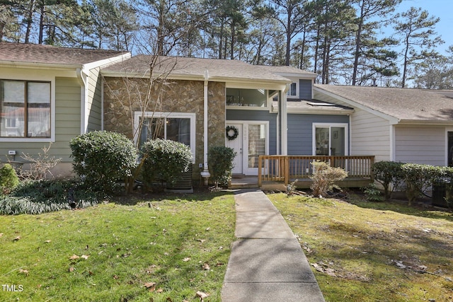 view of front facade with stone siding and a front yard