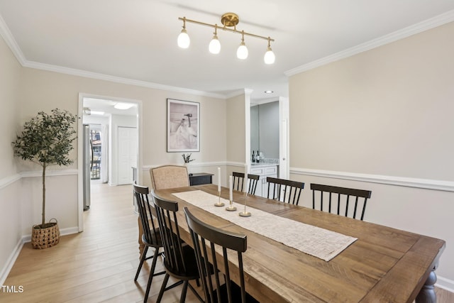 dining room featuring ornamental molding and light wood finished floors