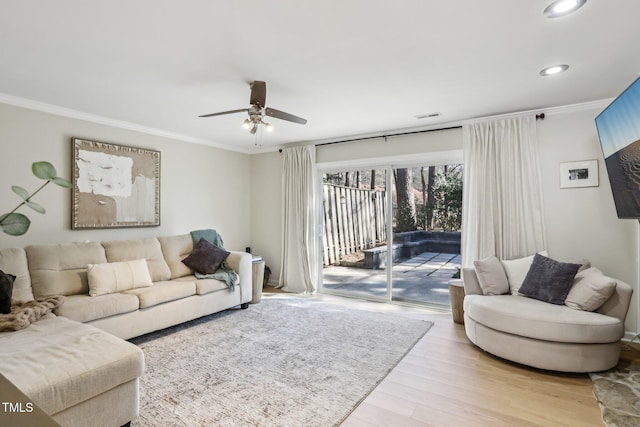 living area featuring recessed lighting, wood finished floors, visible vents, a ceiling fan, and ornamental molding