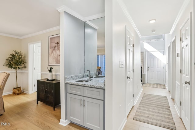 bathroom with vanity, baseboards, crown molding, and wood finished floors