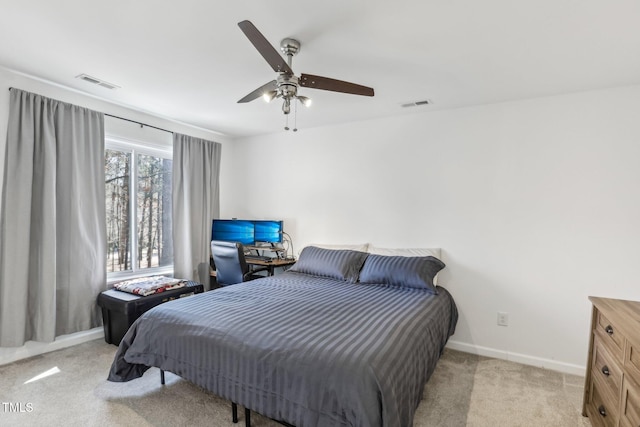 bedroom with baseboards, a ceiling fan, visible vents, and light colored carpet