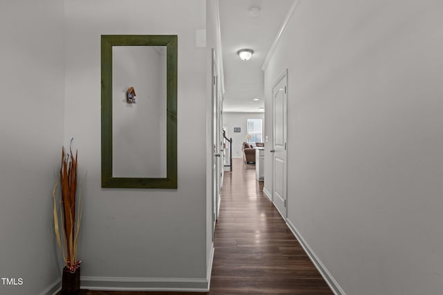 hall with dark wood-style flooring and baseboards