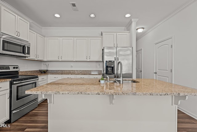 kitchen featuring crown molding, a breakfast bar area, appliances with stainless steel finishes, and a sink