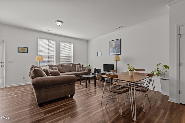 living room with visible vents, crown molding, and wood finished floors