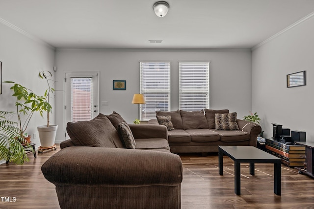 living area with visible vents, dark wood finished floors, and ornamental molding