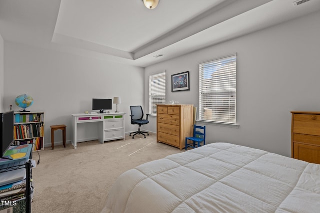 bedroom with baseboards, a tray ceiling, visible vents, and light colored carpet