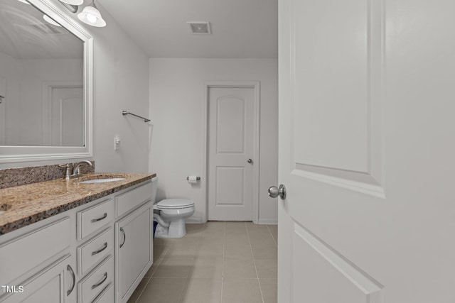 full bathroom with double vanity, visible vents, toilet, a sink, and tile patterned floors