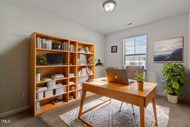 carpeted office space featuring baseboards and visible vents