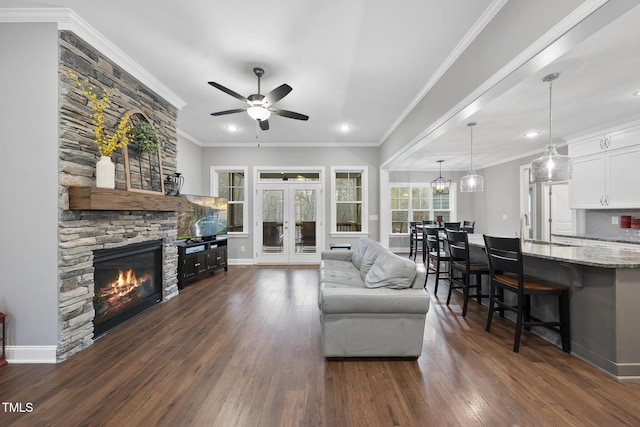 living area with dark wood finished floors, french doors, a fireplace, and ornamental molding