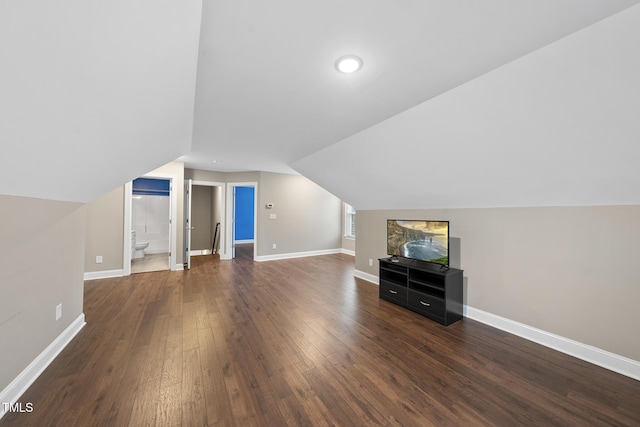 additional living space with baseboards, lofted ceiling, and dark wood-style floors