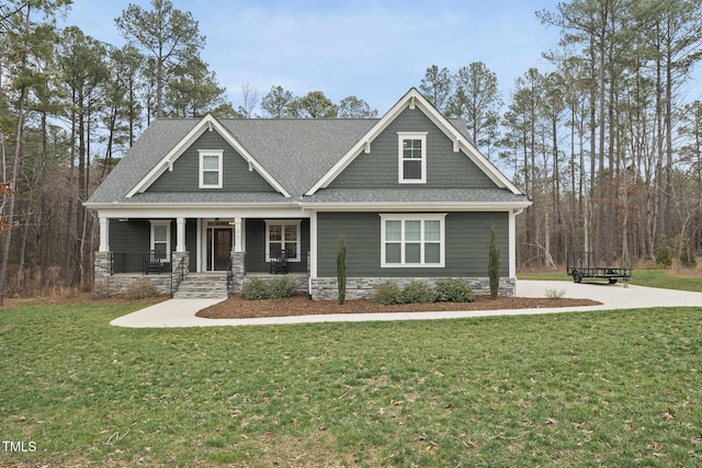 craftsman inspired home with stone siding, a porch, a shingled roof, and a front yard