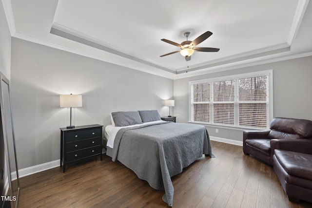 bedroom featuring baseboards, a tray ceiling, and dark wood-style flooring