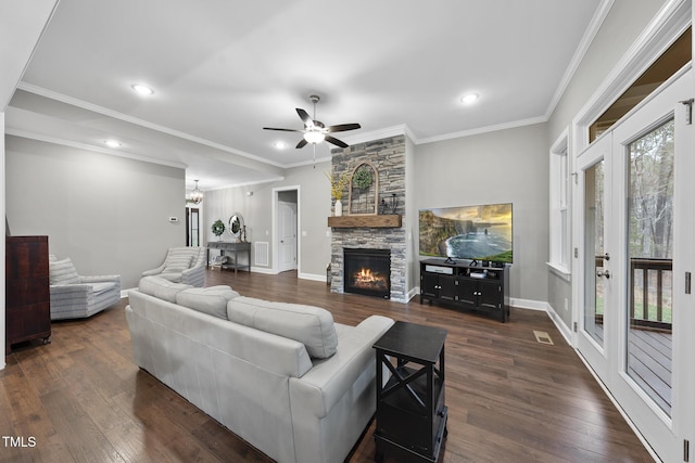 living room featuring a fireplace, crown molding, dark wood-style floors, and visible vents