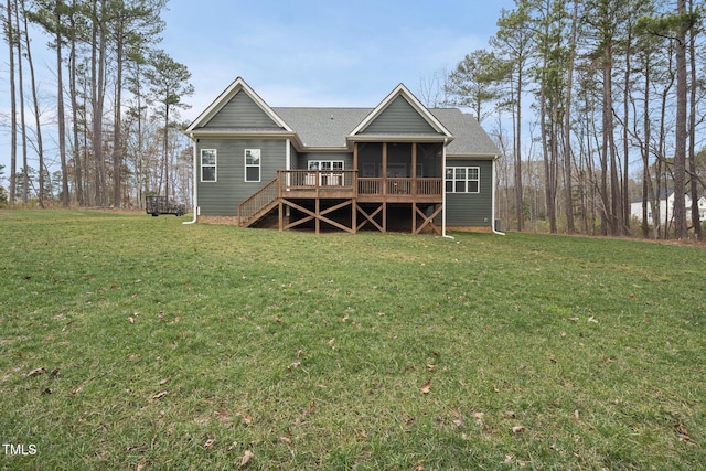 rear view of house with a yard, stairway, roof with shingles, a sunroom, and a wooden deck