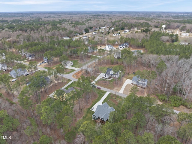 birds eye view of property featuring a view of trees