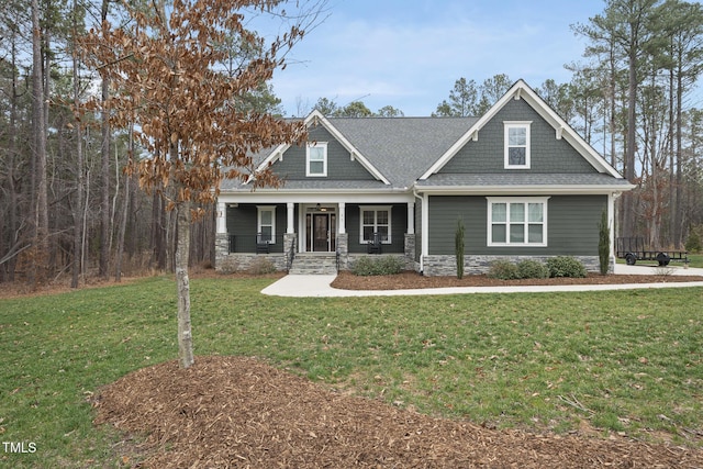 craftsman house featuring a porch, a front yard, and a shingled roof