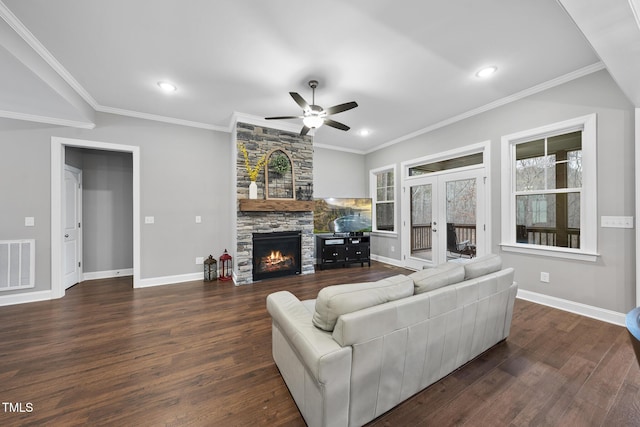 living area featuring visible vents, baseboards, a stone fireplace, and dark wood-style floors