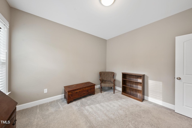 living area featuring baseboards and carpet