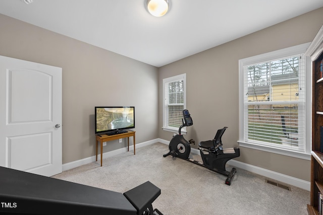 exercise room featuring carpet flooring, visible vents, and a wealth of natural light